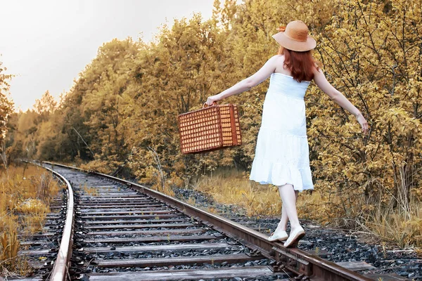 Automne parc fille en blanc robe de soleil et une valise en osier marche — Photo