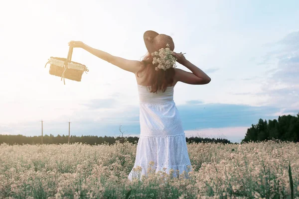 Девушка в белом платье в поле желтых цветов цветущих — стоковое фото