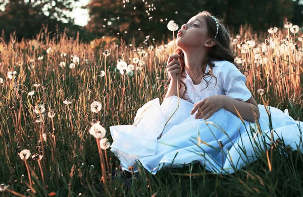 Дівчина дме насіння з квіткової кульбаби восени — стокове фото