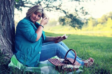 kadın yatıyordu ve kitap Güneş okuyun