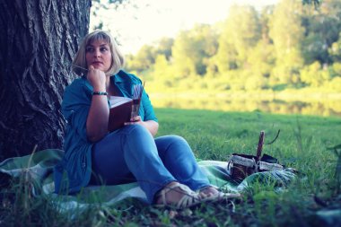 kadın yatıyordu ve kitap Güneş okuyun