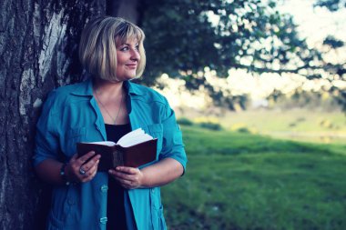 kadın yatıyordu ve kitap Güneş okuyun