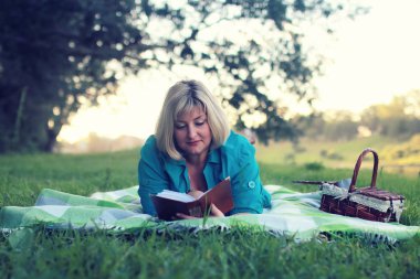 kadın yatıyordu ve kitap Güneş okuyun