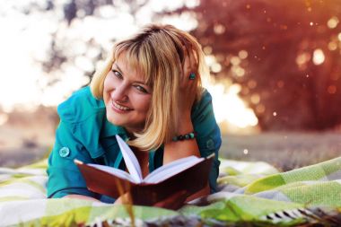 kadın yatıyordu ve kitap Güneş okuyun