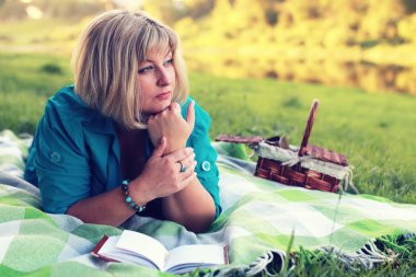 kadın yatıyordu ve kitap Güneş okuyun