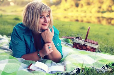 kadın yatıyordu ve kitap Güneş okuyun