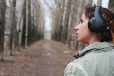Sonbaharda parkta kulaklıklı bir kadın.