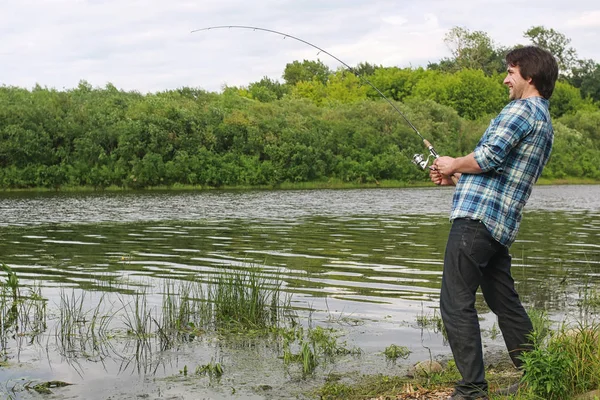 Un hombre con barba está pescando en el río — Foto de Stock