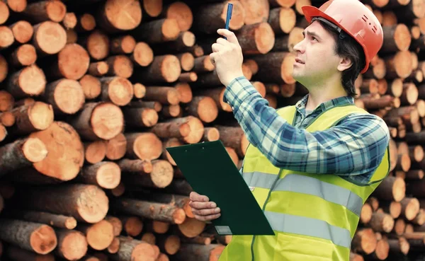 Lavoratore in casco conta legname di legno — Foto Stock