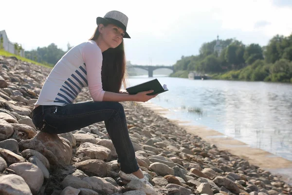 Fille lecture extérieure livre pierre rivière — Photo