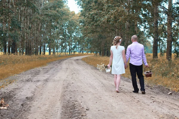 Net getrouwd liefhebbers wandelen in een veld in herfstdag — Stockfoto