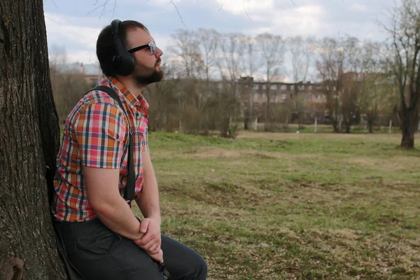 Barba uomo con ascoltare musica nel parco — Foto Stock