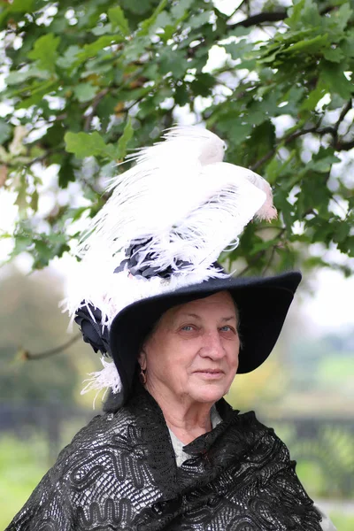 Vieille femme chapeau plume — Photo