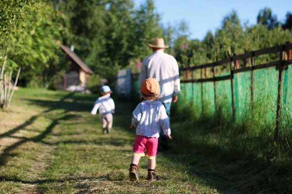 Двоє дітей ходять дідусем — стокове фото