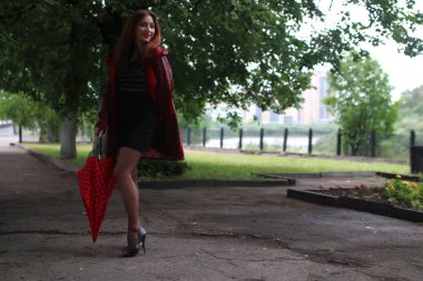 kadın bir yağmurluk ve şemsiye