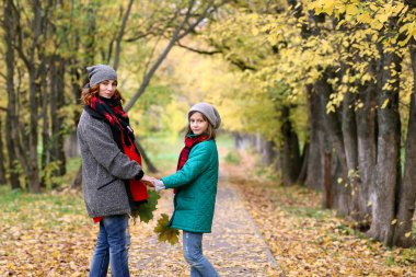 Anne ve kızı sonbahar parkta bir yürüyüş üzerinde
