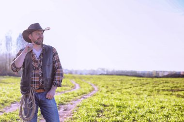 Bir alanda gün batımında ayakta kovboy