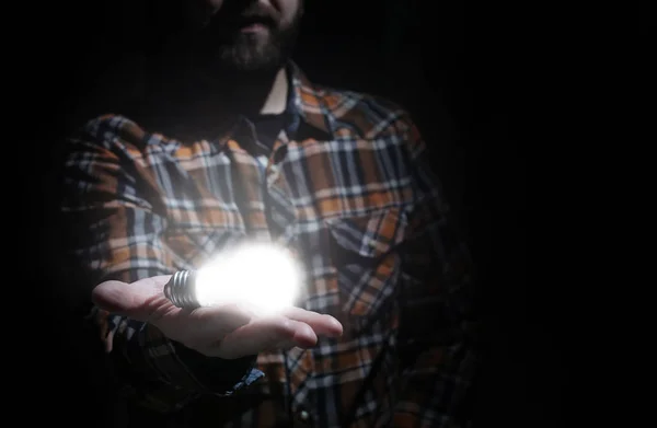 Człowiek trzymać lampę świecącą w ręku — Zdjęcie stockowe