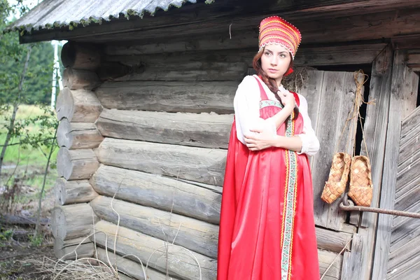 Девушка в традиционном платье деревянная стена — стоковое фото