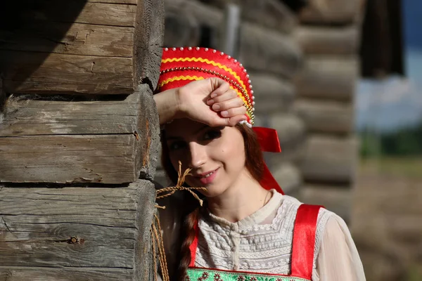 Menina em parede de madeira vestido tradicional — Fotografia de Stock