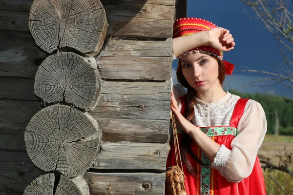 Chica en vestido tradicional pared de madera — Foto de Stock