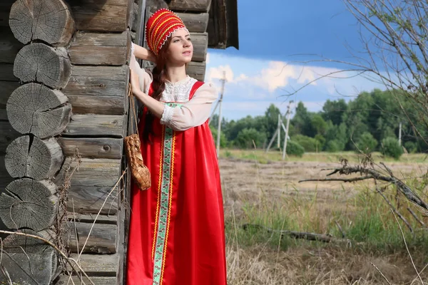 Menina em parede de madeira vestido tradicional — Fotografia de Stock