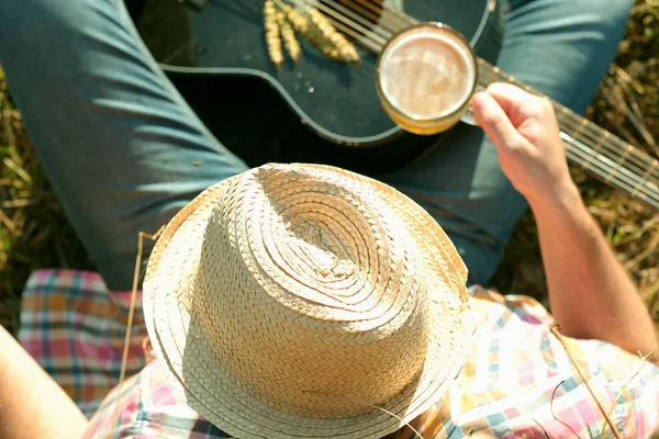 Man med gitarr och öl på natur — Stockfoto