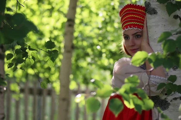 Slav in traditional dress hiding behind trees — Stock Photo, Image
