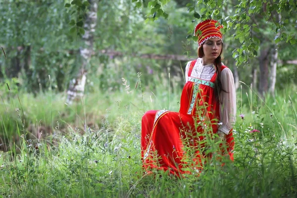 Σλαβική σε παραδοσιακό φόρεμα κάθεται στη φύση — Φωτογραφία Αρχείου