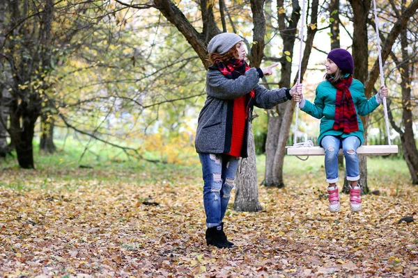 Mamá y su hija en un paseo por el parque de otoño — Foto de Stock