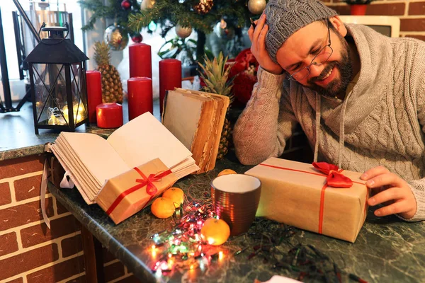 beard man writing christmas gifts on a table