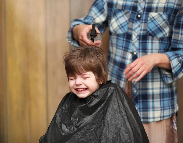Mały chłopiec jest przycinany w jaskrawych emocji Fryzjer — Zdjęcie stockowe