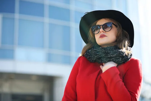 Femme d'affaires mignonne dans un manteau rouge sur un fond de verre — Photo