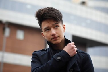 Asya genç adam sokakta bir ceket