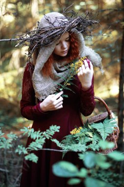 Kızıl saçlı cadı bir ritüel bir kristal top ile tutar