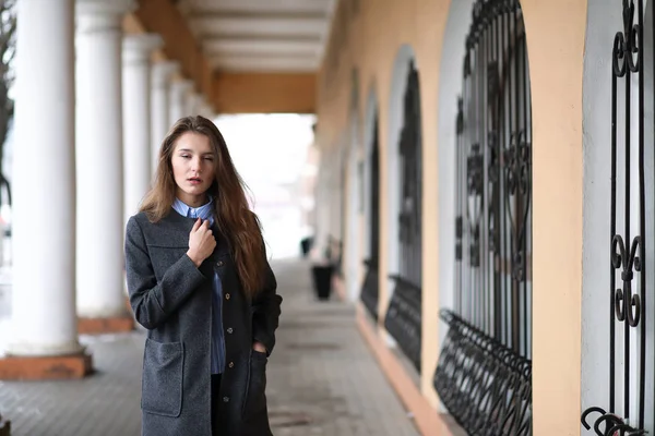 Menina bonita nova em um passeio perto do edifício com uma coluna — Fotografia de Stock