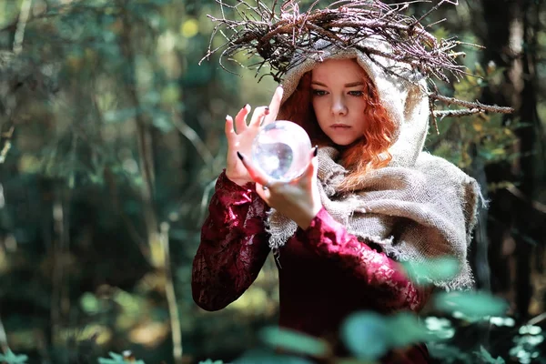 La sorcière rousse tient un rituel avec une boule de cristal — Photo