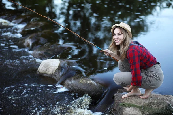 Una chica en un río rápido de pesca con caña —  Fotos de Stock