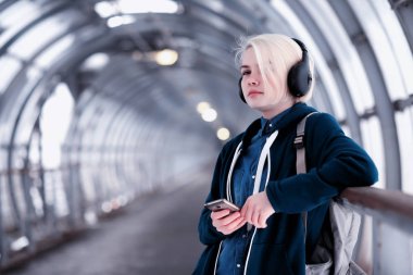 Genç öğrenci metro büyük kulaklıklar müzik dinlemek