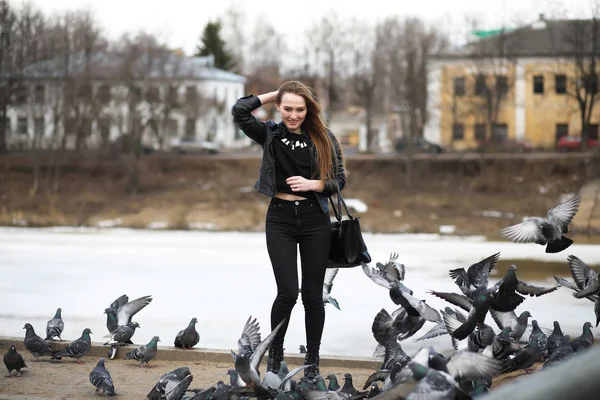 Mädchen beim Spaziergang im Park und eine Schar Tauben — Stockfoto