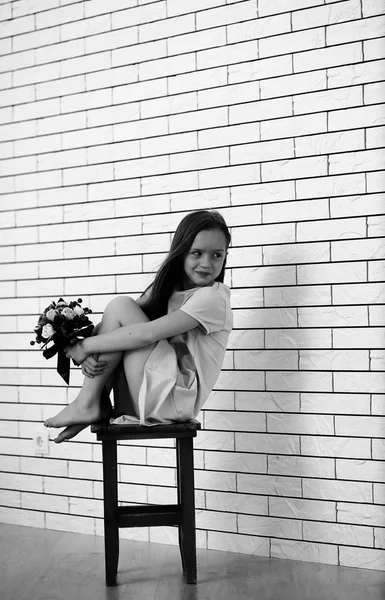 Маленькая девочка на стуле чёрно-белая — стоковое фото