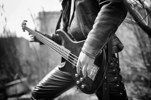 Rockový kytarista venkovní. Hudebník s basová kytara v kožená — Stock fotografie