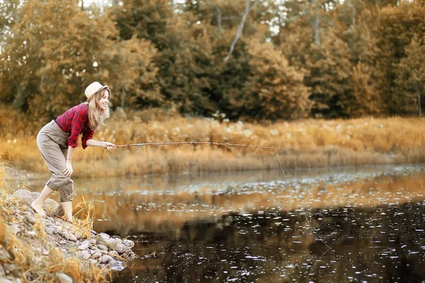 Fille en automne avec une canne à pêche — Photo