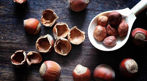 Nozes em uma mesa de madeira.Avelãs nas conchas e descascadas. Um wo — Fotografia de Stock