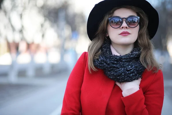 Красивая девушка на прогулке в красном пальто в городе — стоковое фото