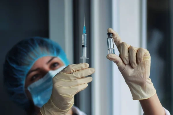 nurse hands holding syringe and ampoule