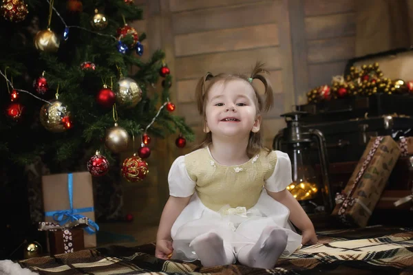 Criança está sentada com decorações de Natal — Fotografia de Stock