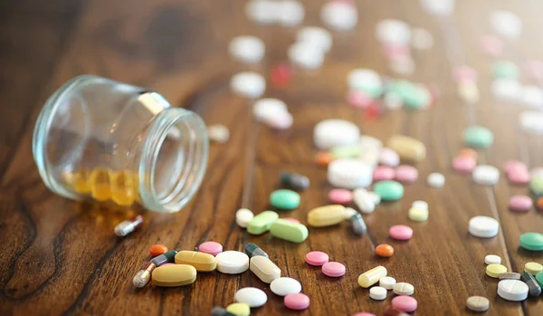 Narkotyków i monety w szklanym słoju na drewnianą podłogę. Pocket oszczędności — Zdjęcie stockowe