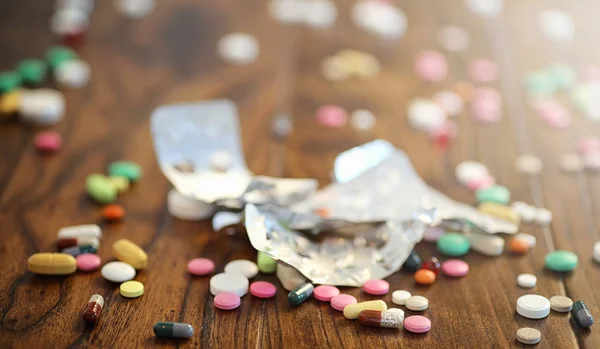 Drogas y monedas en un frasco de vidrio en un suelo de madera. Ahorro de bolsillo — Foto de Stock