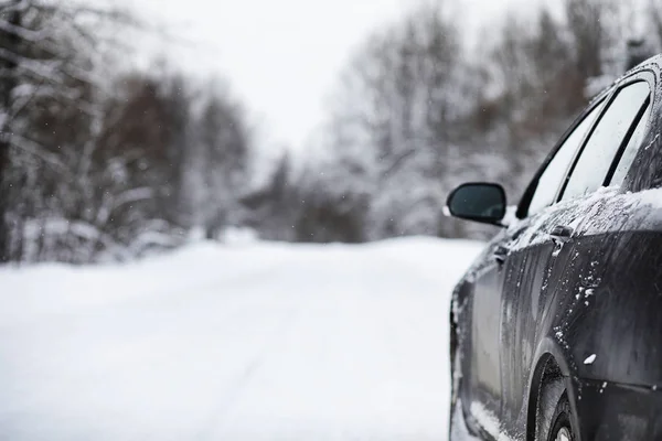 El coche se encuentra en una carretera cubierta de nieve —  Fotos de Stock
